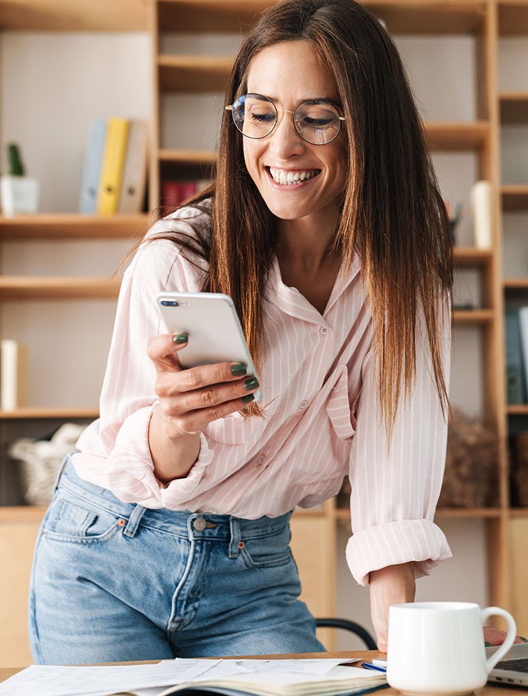 Confident woman working on phone – representing Owl Luminous branding and business support for women.